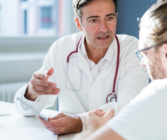 Zwei Ärzte unterhalten sich über Impfstoffe und Studiendaten.