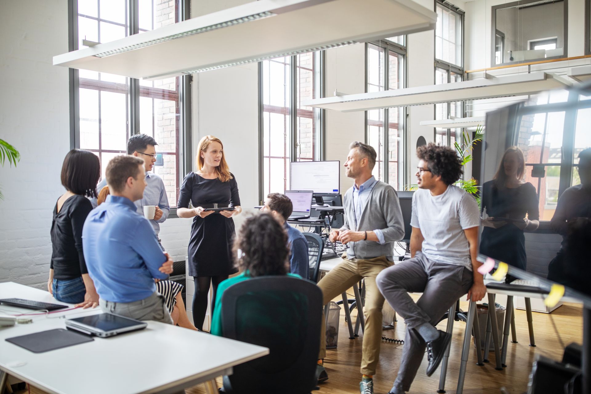 Ein Team-Meeting von acht Personen in einem großzügigen Büro