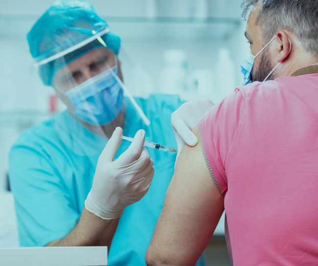Ein Patient erhält eine Spritze in den Oberarm