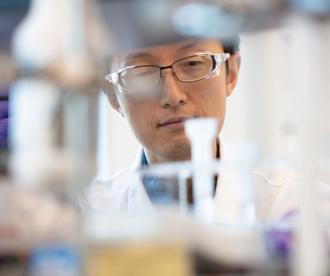 Ein Wissenschaftler steht vor Laborapparaturen.