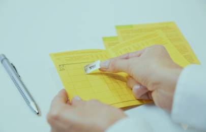 Impfsticker wird in einen Impfpass geklebt