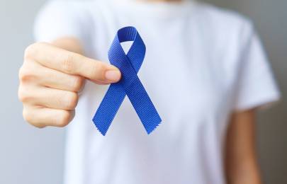 Person zeigt blaues Band geformt wie eine Schleife