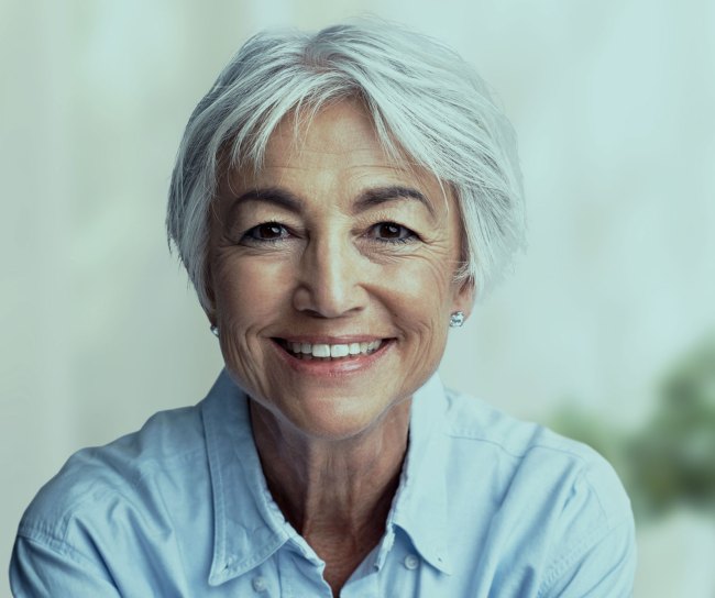 Eine 60-jährige Frau lächelt in die Kamera.