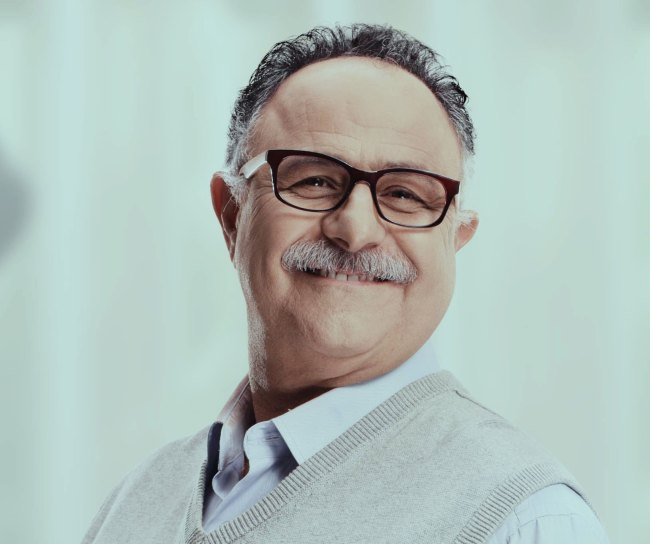 Ein 60-jähriger Mann lächelt in die Kamera.
