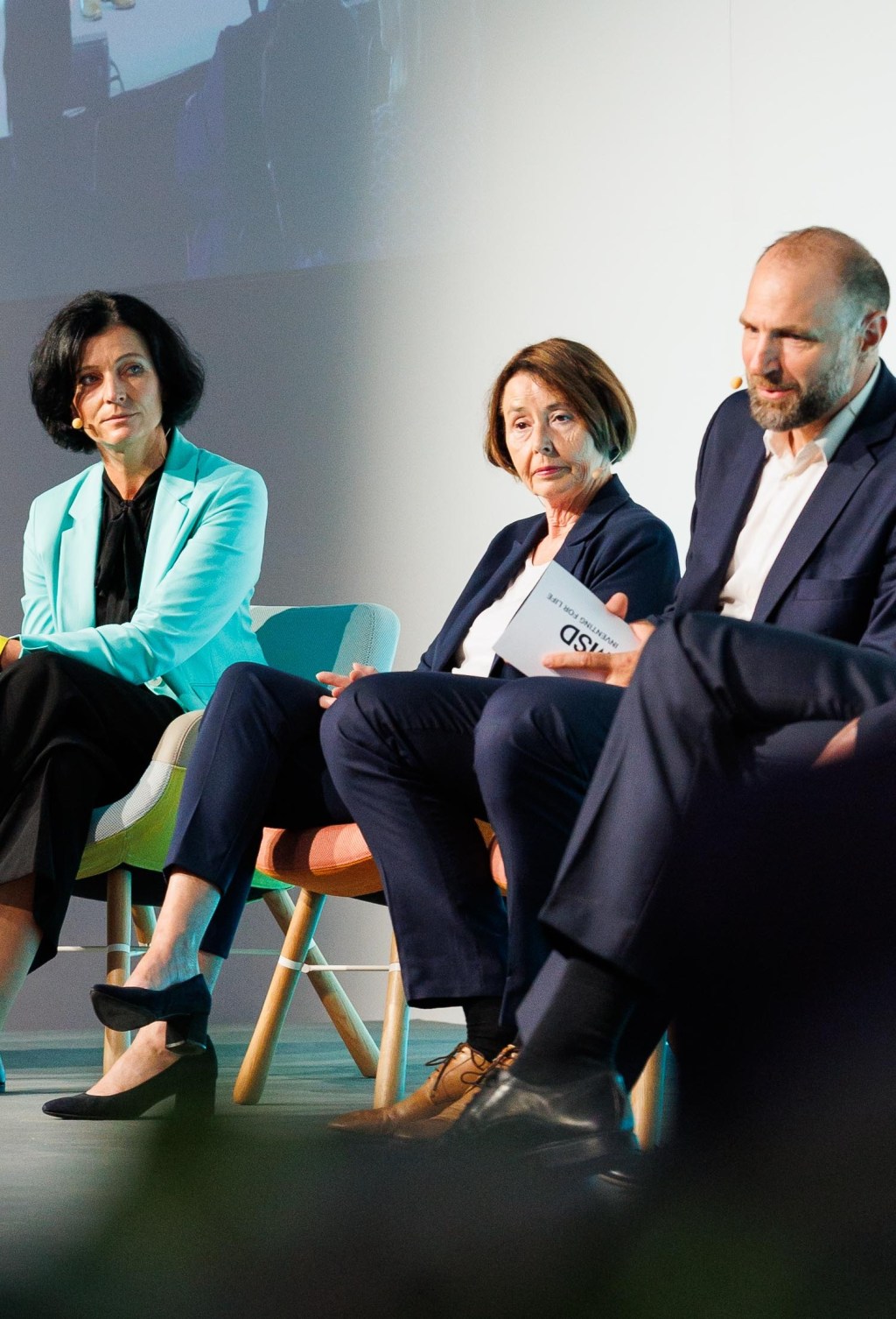 Teilnehmende der Podiumsdiskussion zum Thema Return to better care im Gespräch auf der Bühne des Gesundheitsforums.
