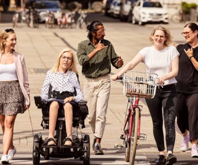 Menschen mit und ohne Behinderung sind gemeinsam unterwegs, um unser Engagement für eine inklusive Führungskultur zu symbolisieren