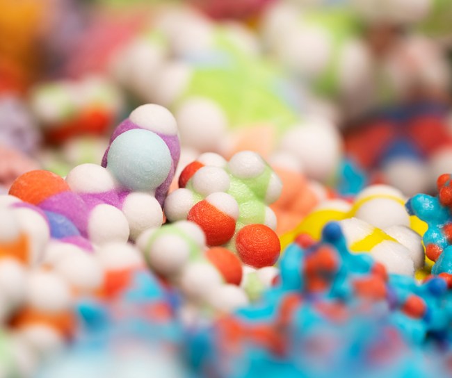Makroaufnahme eines bunten molekularen 3D-Modells, das komplexe chemische Strukturen in intensiven Farben darstellt.